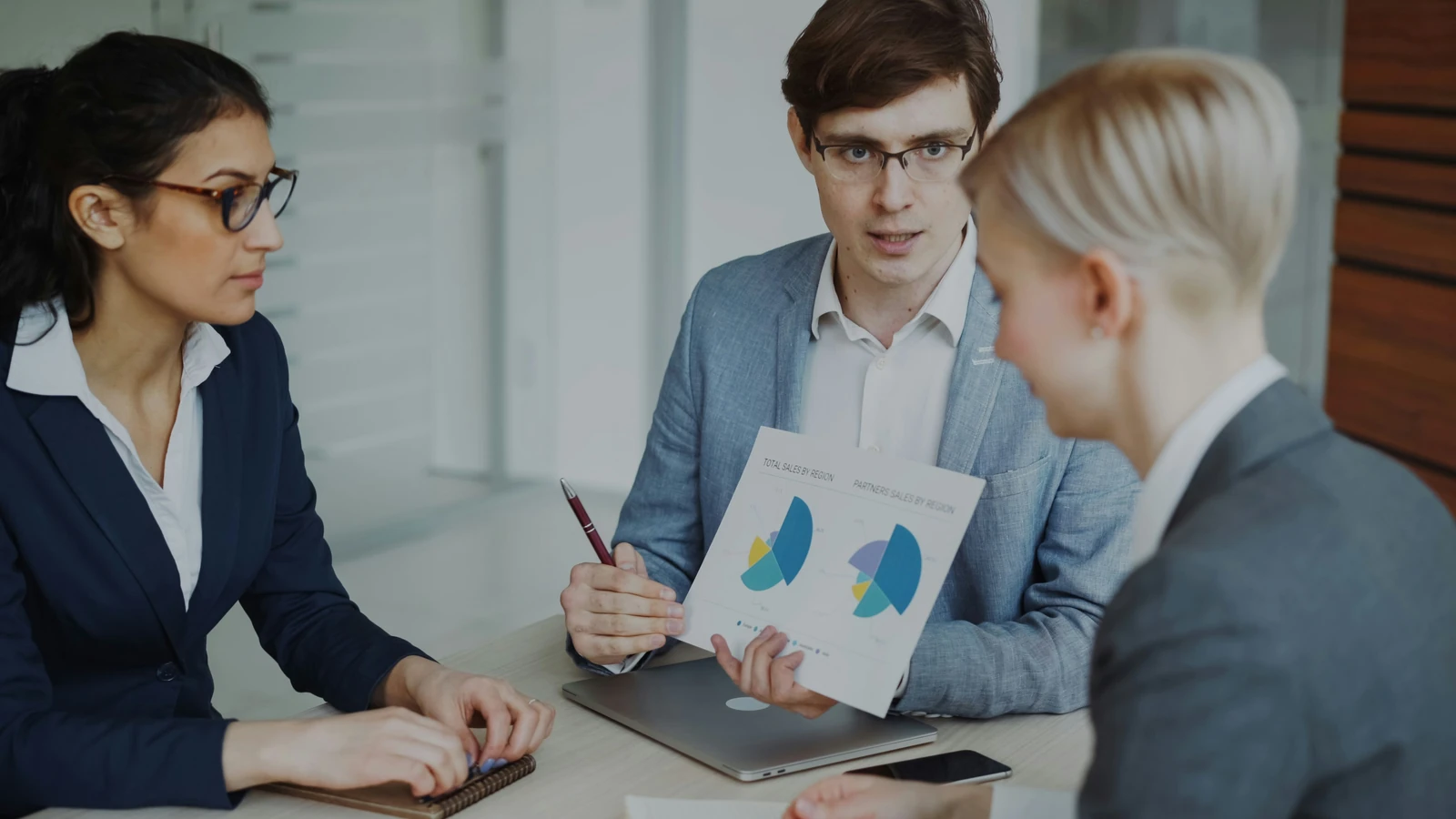 Colleagues reviewing business figures together in an office.